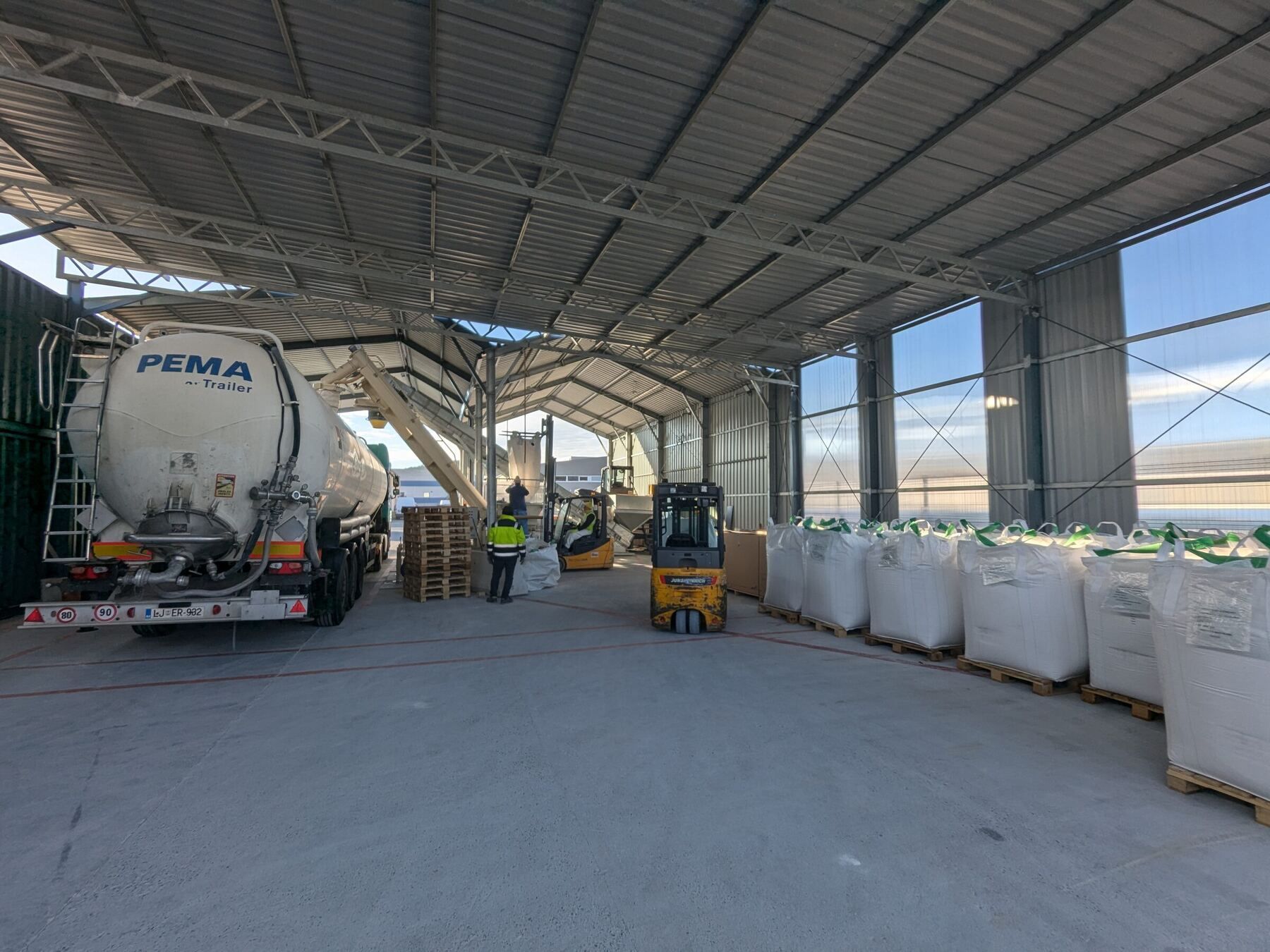 Silo cisterna in viličar z big-bag vrečami v pokriti hali Capris Trans na Kozini med prekladom razsutega blaga.