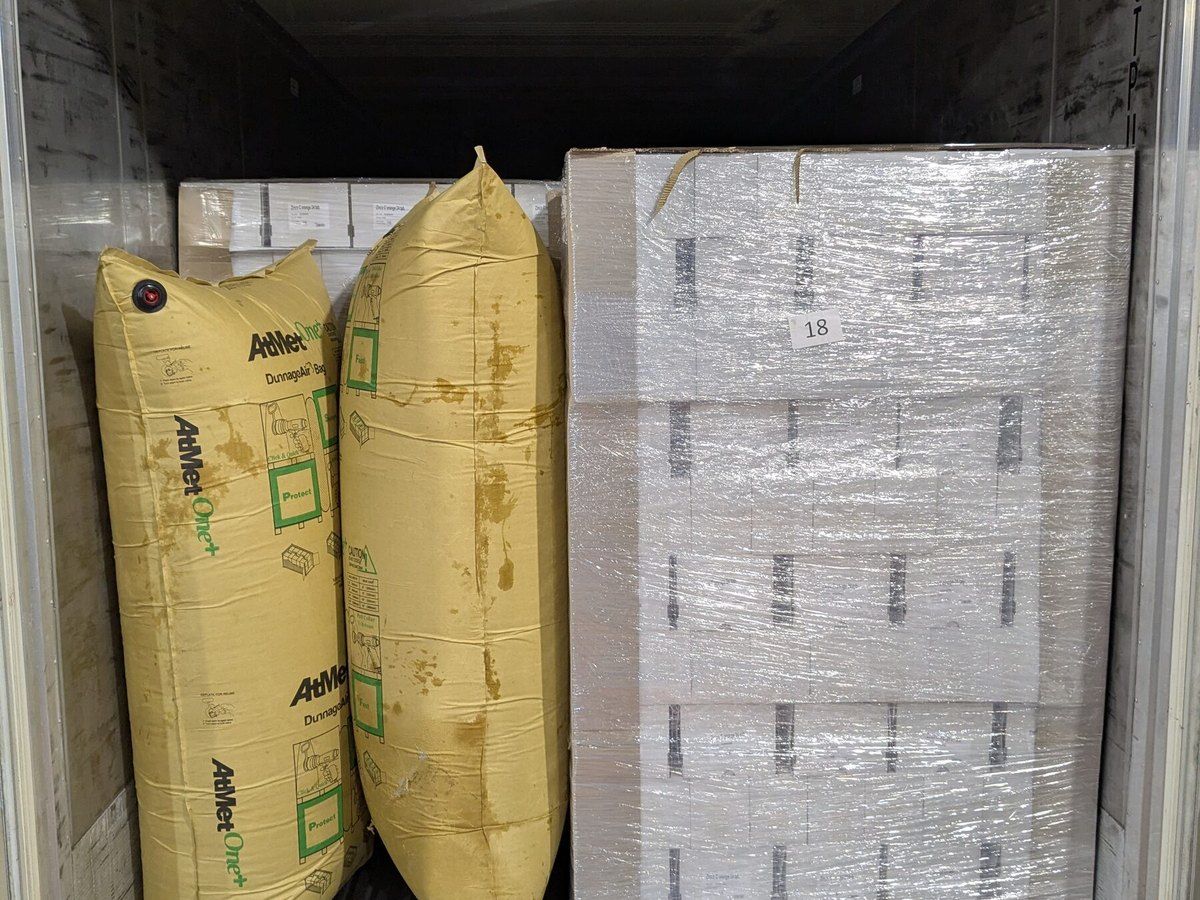 Film-wrapped pallets and air bags in a container.